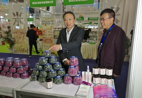 省委臺辦主任周敏謙(左)在四川雙龍農牧開發(fā)有限公司展臺與臺商林云飛(右)親切交流