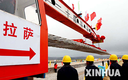 西藏境內(nèi)第一段鐵路軌排在安多火車站鋪下,鐵軌將從這里向拉薩繼續(xù)延伸(2004年6月22日攝)。 青藏鐵路從西寧至拉薩全長1956公里,是世界上海拔最高、線路最長、穿越凍土里程最長的高原鐵路。把鐵路修進(jìn)西藏是幾代中國人的夢想,但這一想法直到新中國成立后才逐漸變?yōu)楝F(xiàn)實(shí)。青藏鐵路一期工程西寧至格爾木段于1958年開工,1984年交付營運(yùn)。但限于當(dāng)時(shí)國家的經(jīng)濟(jì)實(shí)力以及高原、凍土等筑路技術(shù)難題尚未解決,格爾木至拉薩段被迫停建。2001年6月,國家總投資330.9億元?jiǎng)庸ば藿ㄇ嗖罔F路二期工程。這一工程跨越昆侖山、唐古拉山,通過多年凍土層和大片“生命禁區(qū)”,是人類鐵路建設(shè)史上亙古未有的穿越。它的建成將為神秘而古老的青藏高原帶來新的生機(jī)和活力! 新華社發(fā)